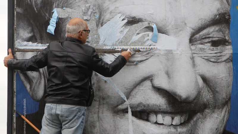 Fotografija: Activists of Egyutt (Together) opposition party removes a government billboard displaying George Soros in monochrome next to a message urning Hungarians to take part in a national consultation about what it calls a plan by the Hungarian-born financier to settle a million migrants in Europe per year, in Budapest, Hungary, October 5, 2017. REUTERS/Bernadett Szabo - RC150C929800