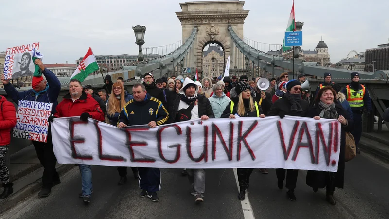 Fotografija: »Dovolj imamo!« je sporočilo, ki ga protestniki z ulic pošiljajo Viktorju Orbanu in stranki Fidesz. FOTO: Ferenc Isza/AFP