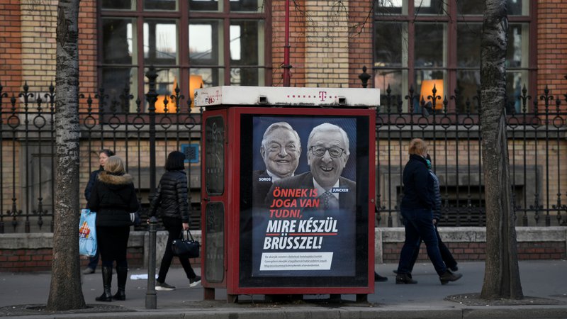 Fotografija: V plakatni kampanji je ob milijarderju Georgeu Sorosu tarča napadov tudi predsednik evropske komisije Jean-Claude Juncker. Foto: Tamas Kaszas/Reuters