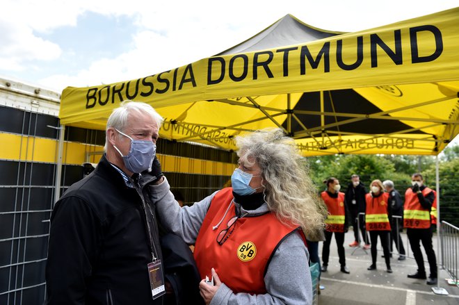 Današnji dan prinaša tradicionalni porurski derbi v Dortmundu. Takole so pred vhodom na štadion preverjali temperaturo članom ene od snemalnih ekip. FOTO: Reuters