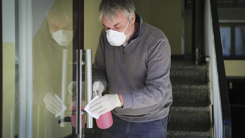 Fotografija: Z vodo in detergentom je še vedno potrebno čistiti kljuke, stikala in ograje, ob vhod namestiti razkužilo za roke, skupni prostori pa se morajo večkrat na dan zračiti. FOTO: Jože Suhadolnik/Delo