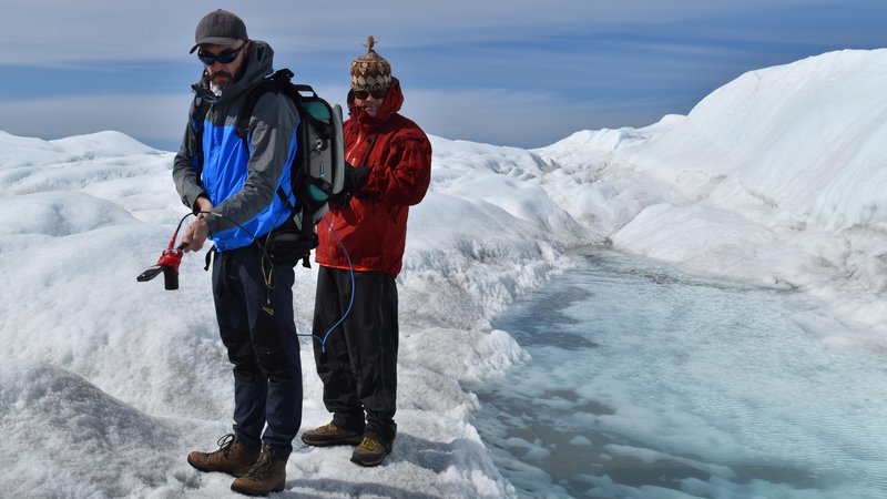 Fotografija: Marco Tedesco (levo) in sodelavec med merjenjem odbojnosti grenlandskega ledu na odpravi leta 2018. Foto Kevin Krajick, Earth Institute
