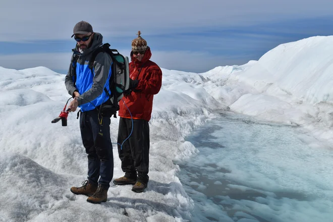 Marco Tedesco (levo) in sodelavec med merjenjem odbojnosti grenlandskega ledu na odpravi leta 2018. Foto Kevin Krajick, Earth Institute
