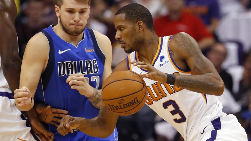 Fotografija: Luka Dončić (ustavlja napad Trevorja Arize) je ob debiju prispeval 10 točk. FOTO: Matt York/AP