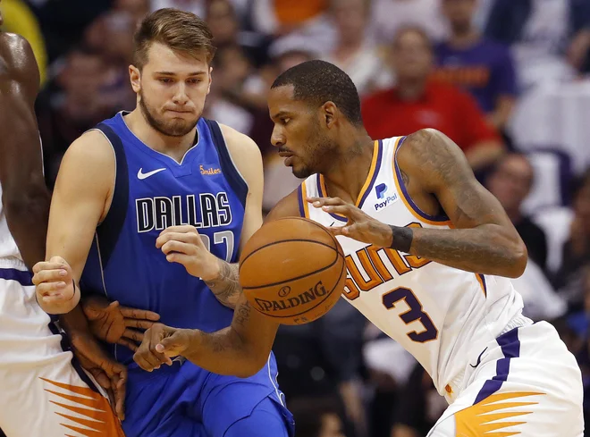 Luka Dončić (ustavlja napad Trevorja Arize) je ob debiju prispeval 10 točk. FOTO: Matt York/AP