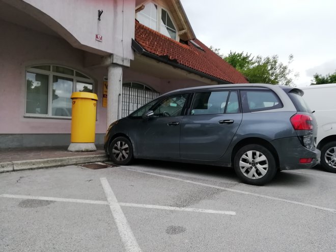Poškodovano vozilo, parkirano pred poslovalnico Pošte Slovenije v Stražišču. FOTO: Janez Porenta