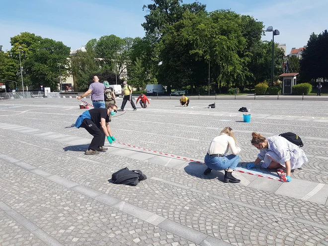 Protestniki na ograjen Trg republike zapisujejo »Naša last«. FOTO: Mojca Zabukovec