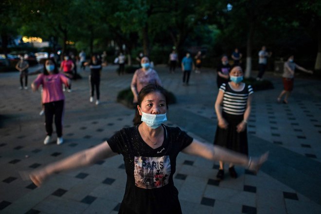 Prebivalci kitajskega mesta Wuhan, od koder se je razširil novi koronavirs. FOTO: Hector Retamal/AFP