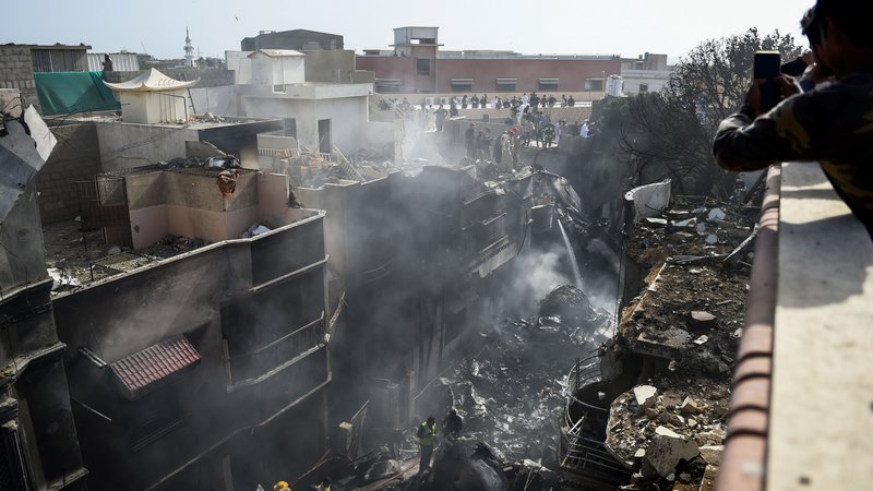 Fotografija: Letalo je strmoglavilo v stanovanjsko soseko v mestu Karači. FOTO: Rizwan Tabassum/AFP