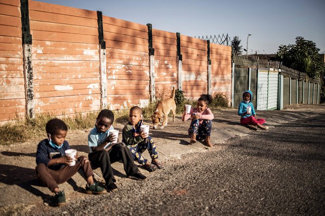 Otroci, ki v Johannesburgu čakajo na brezplačni obrok. FOTO: Marco Longari/AFP