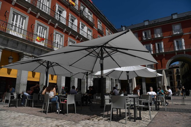 Po desetih tednih karantene so v najbolj okuženih španskih mestih, Madridu in Barceloni, danes spet lahko odprli bare in restavracije. Na fotografiji prizor s Plaza  Mayor, osrednjega trga v Madridu. FOTO: Pierre-Philippe Marcou/AFP