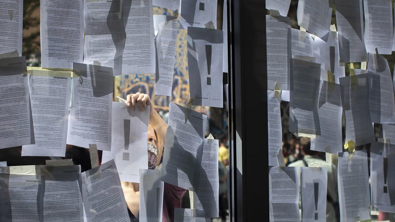 Fotografija: Umetniki so okna ministrske zgradbe prelepili z listi papirja z neodgovorjenimi vprašanji, dopisi, pozivi in pobudami. FOTO: Voranc Vogel/Delo