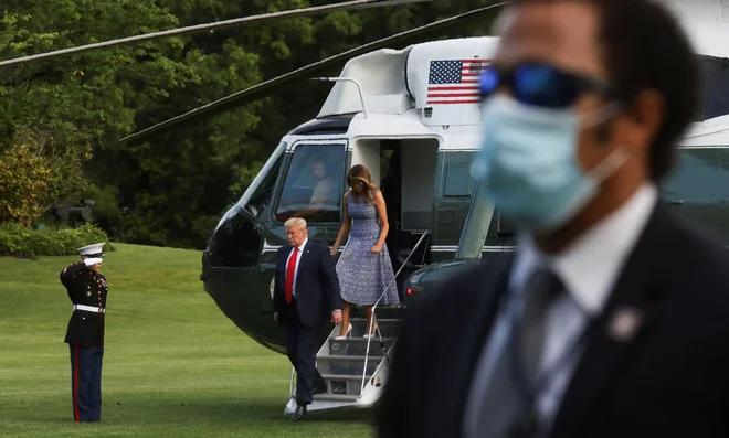 Predsednik ZDA Donald Trump ob prihodu na Florido, kjer si je nameraval ogledati prvo izstrelitev astronavtov v vesolje z ameriških tal po letu 2011, ni nosil zaščitne maske, prav tako ni komentiral, da je v ZDA število smrtnih žrtev zaradi covida-19 včeraj preseglo mejnik 100.000. Zaradi okužbe je tako umrlo že več Američanov kot v korejski, vietnamski in iraški vojni od leta 2003 do 2011 skupaj. FOTO: Leah Millis/Reuters