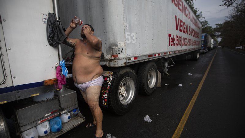 Fotografija: 44-letni voznik tovornjaka Mauricio Vasquez med blokado na meji Penas Blancas med Nikaragvo in Kostariko v Rivasu. Na tisoče tovornjakov iz Nikaragve je v sredo iz maščevanja blokiralo južno mejo, zaradi sanitarnih omejitev, ki jih je Kostarika uvedla za prevoz tovora, da bi preprečile širjenje novega koronavirusa. FOTO: Inti Ocon/Afp