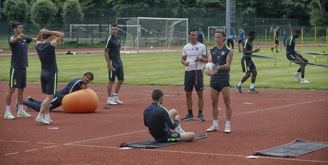 Nogometaši Olimpije so se pripravljali tudi na Kodeljevem. Takole sta si med enim od treningov pomagala Bojan Knežević (na tleh) in Stefan Savić. FOTO: Blaž Samec