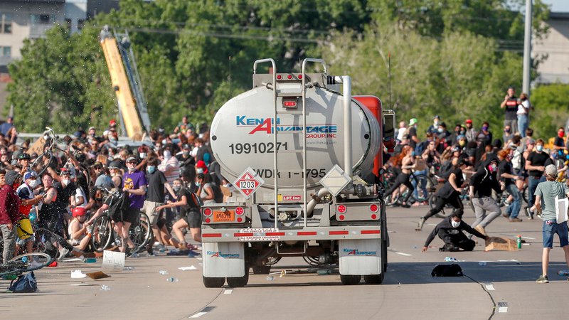 Fotografija: V Minneapolisu, kjer je Floyd tragično umrl med aretacijo, je voznik tovornjaka cisterne zapeljal proti množici protestnikov, ki je korakala po eni od glavnih cest. Protestniki so se še pravočasno umaknili, nato pa voznika cisterne potegnili iz vozila in ga pretepli. S poškodbami je bil odpeljan v bolnišnico. Motiv dejanja še ni znan. FOTO: Eric Miller/Reuters