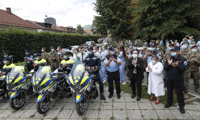 Pripadniki 15. polka vojaškega letalstva Slovenske vojske in 31. lovskega polka Vojnega letalstva ZDA so ob koncu epidemije covida-19 opravili skupen prelet nad Slovenijo. V tem času so patrulje policije v neposredni bližini bolnišnic prižgale modre luči. Pred infekcijsko kliniko so se zbrali policisti, vojaki, medicinsko osebje in civilna zaščita. FOTO: Leon Vidic/Delo