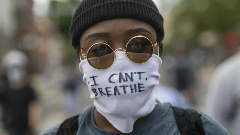 Fotografija: Protestnik z masko, na kateri so zapisane zadnje besede Georgea Floyda "Ne morem dihati!" Foto Mark Makela Afp