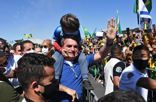 Braziliski predsednik Jair Bolsonaro, ki si je prislužil hude očitke o neustzreznem odzivu na epidemijuo koronavirusa, se med svojimi podporniki počuti odlično, toda v največji južnoameriški državi so glasni in številni tudi njegovi nasprotniki. FOTO: AFP