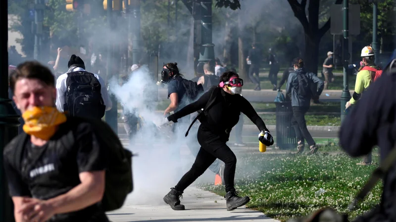 Fotografija: Protestnik v Minneapolisu meče pločevinko s solzivcem nazaj proti policistom. Foto Reuters