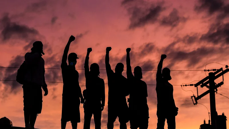 Fotografija: TOPSHOT - People raise their hands and shout slogans as they protest at the makeshift memorial in honour of George Floyd, on June 2, 2020 in Minneapolis, Minnesota. - Thousands of National Guard troops patrolled major US cities after protests over racism and police brutality boiled over into arson and looting, sending shock waves through the country. (Photo by CHANDAN KHANNA / AFP)