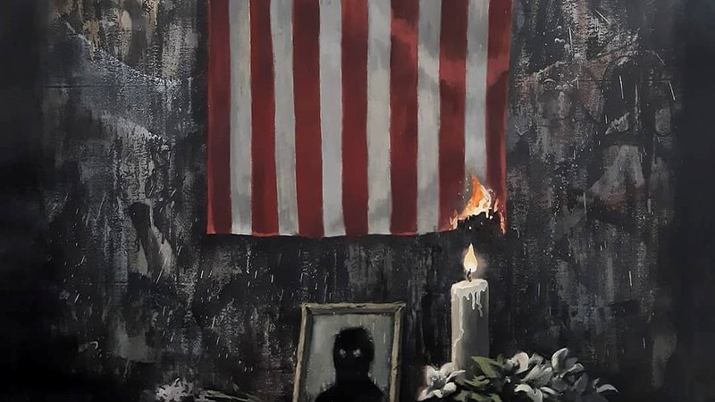Fotografija: Sveča, ki na Banksyjevi podobi gori v poklon Georgeu Floydu, z ognjem načenja tudi simbol ZDA, državno zastavo. FOTO: @banksy Instagram/Reuters