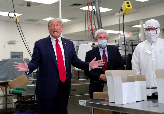 Ameriški predsednik nikoli v javnosti ne nosi zaščitne maske, tudi v tovarni medicinske opreme ne. FOTO: Tom Brenner/Reuters