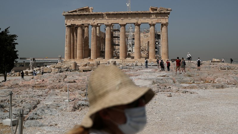 Fotografija: Obrazne maske so stalnica grškega turizma. Od uspeha sezone je odvisna finančna sposobnost Grčije. FOTO: Alkis Konstantinidis/Reuters