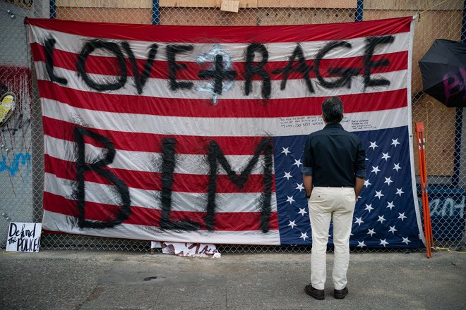 Na ameriški dan zastave na glavo obrnjena in s parolami popisana zastava v Seattlu. FOTO: David Ryder/AFP