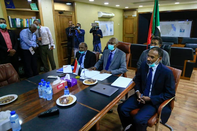 Sudanski minister za namakalne sisteme in vodne vire Yasir Mohamed (v sredini) med videopogovorom o Velikem etiopskem renesančnem jezu. FOTO: Ashraf Shazly/AFP