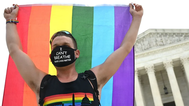 Fotografija: Protestnik za pravice LGBT+ delavcev pred ameriškim vrhovnim sodiščem v prestolnici Washington. Foto Jim Watson/Afp
