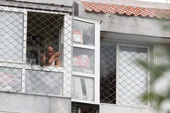 Na območju visokega tveganja v Pekingu, ki obsega 29 sosesk, življenje ljudi znova poteka v karanteni. FOTO: Thomas Peter/Reuters