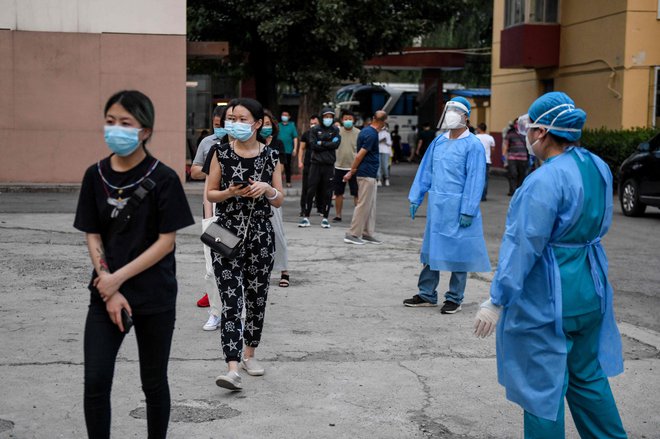 V Pekingu testirajo vse, ki so se v zadnjem tednu mudili na tržnici Xinfadi. Identificirali so jih tudi po avtomobilskih tablicah. FOTO: Greg Baker/AFP