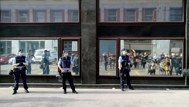 Protestniki se, po nasilnem posredovanju policije, zbirajo pred poslopjem ministrstva za notranje zadeve, kjer prebirajo ustavo. FOTO: Blaž Samec