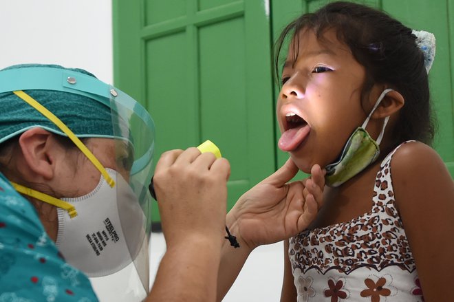 Staroselska deklica med zdravstvenim pregledom v zvezni državi Amazonas, kjer so potrdili največ primerov okužb na 100.000 prebivalcev. FOTO: Evaristo Sa/AFP