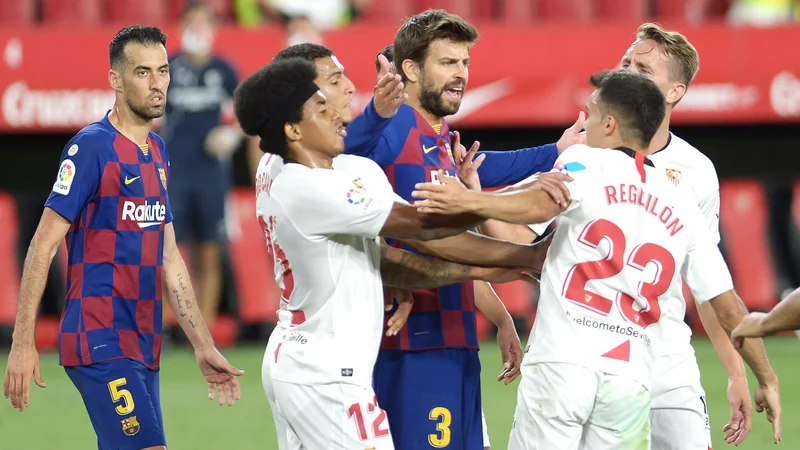 Fotografija: Gerard Pique (Barcelona) se je med tekmo takole jezil na Sergia Reguilona (Sevilla). FOTO: Cristina Quicler/AFP