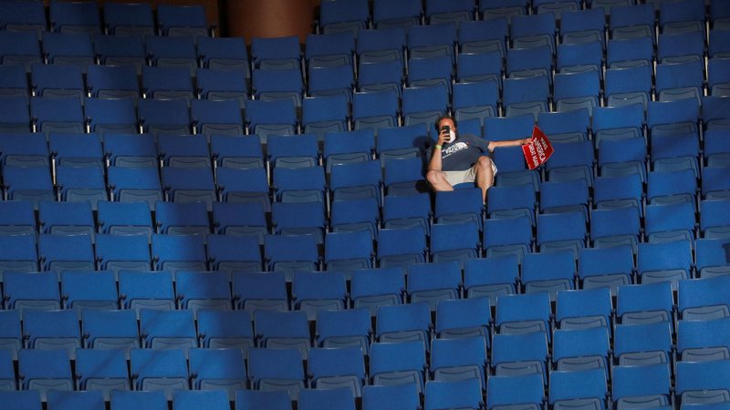 Fotografija: Osamljen Trumpov privrženec v zgodnjem delu arene v Tulsi. FOTO: Leah Millis/Reuters