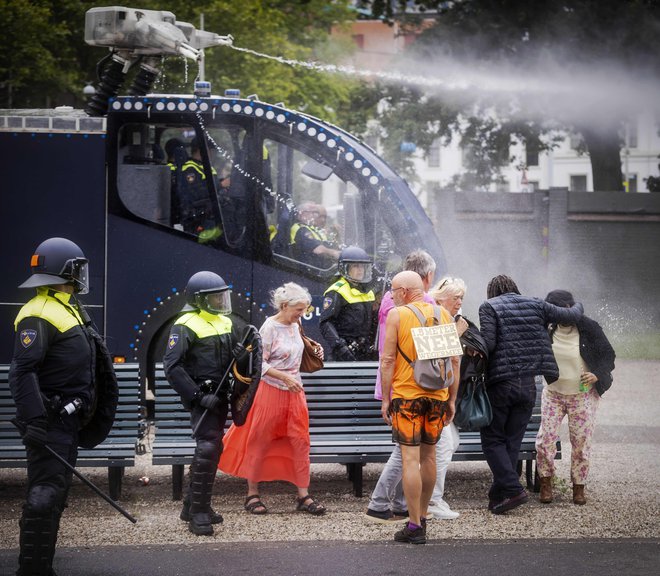 V Haagu so se zbrali nasprotniki ukrepov v času epidemije. Policisti so ob spopadih uporabili vodne topove. FOTO: Robin Van Lonkhuijsen/AFP