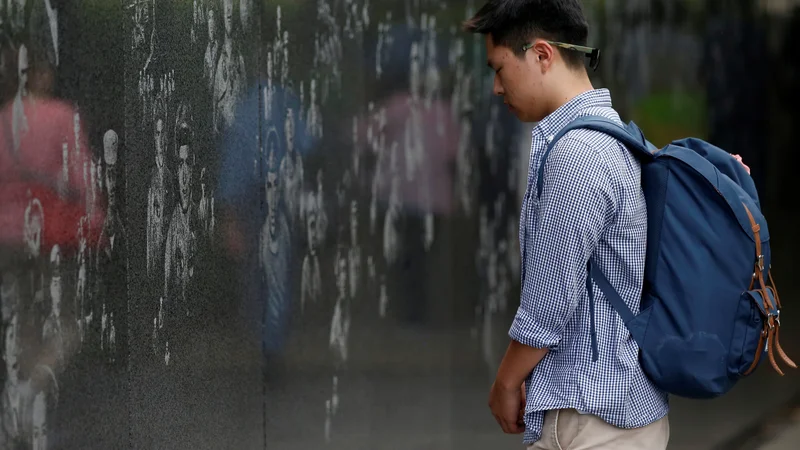 Fotografija: Kanadski južnokorejec Charles Choi stoji pred spomenikom veteranom korejske vojne v Washingtonu. Foto Leah Millis/Reuters