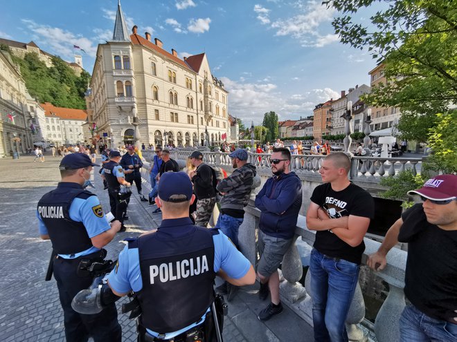 Policisti na Tromostovju popisujejo prisotne pred začetkom alternativne proslave ob dnevu državnosti. FOTO: Jože Suhadolnik/Delo