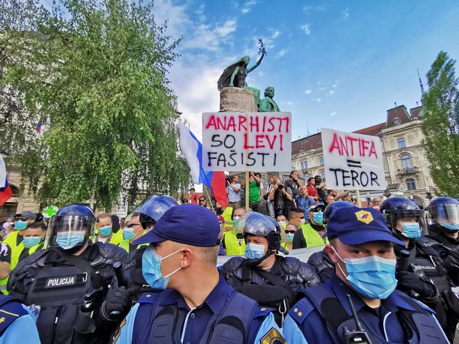 Policisti so se postavili pred skupino, ki je želela zmotiti potek alternativne proslave. FOTO: Jože Suhadolnik/Delo
