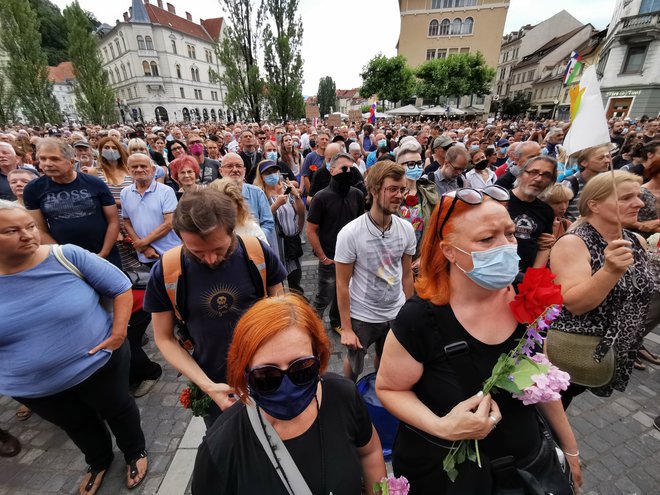 Veliko ljudi je danes na Prešernovem trgu nosilo cvetje. FOTO: Jože Suhadolnik/Delo