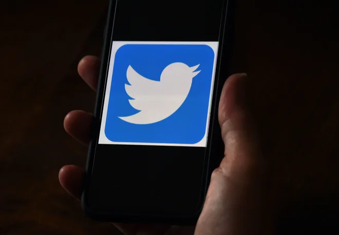 Twitterjev logotip na prenosnem telefonu. Foto Olivier Douliery Afp