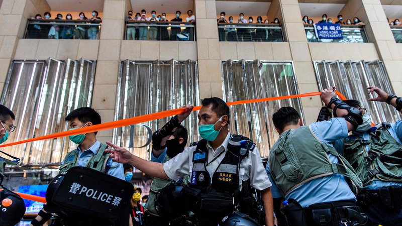 Fotografija: Policijsko preiskovanje trgovskega centra v Hongkongu, kjer ljudje čakajo na začetek današnjega protesta. FOTO: Anthony Wallace/AFP