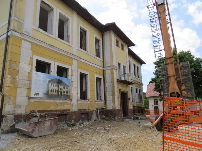 Pred dotrajano nekdanjo osnovno šolo v Višnji Gori, ki je bila zgrajena leta 1906, so gradbinci postavili ogromno dvigalo in začeli z obnovo. FOTO: Bojan Rajšek/Delo