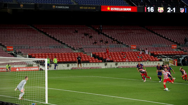 Fotografija: Brez gledalcev je v torek minil tudi derbi španske lige med Barcelono in Atleticom. FOTO: Albert Gea/Reuters