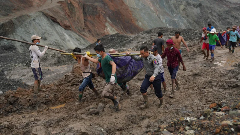 Fotografija: Reševalci iz blata odkopavajo trupla umrlih. FOTO: Zaw Moe Htet/AFP