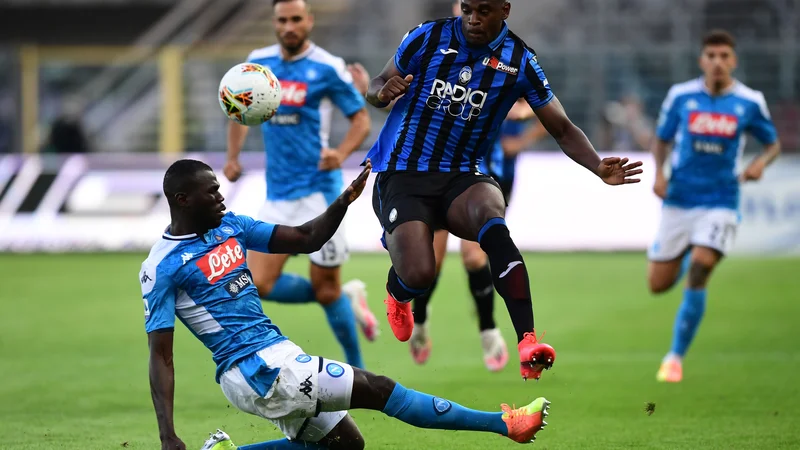 Fotografija: Napolijev branilec Kalidou Koulibaly in Atalantin napadalec Duvan Zapata v eni od akcij. FOTO: Miguel Medina/AFP