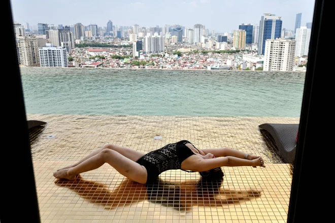 V Hanoju gostja pozira ob bazenu na novo odprtega hotela Dolce Hanoi Golden Lake, prvega pozlačenega hotela na svetu. FOTO: Manan Vatsyayana/Afp