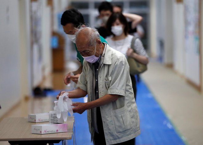 Število okuženih je bilo po svetu včeraj največje od razglasitve pandemije, je sporočila Svetovna zdravstvena organizacija.. FOTO: Issei Kato/Reuters